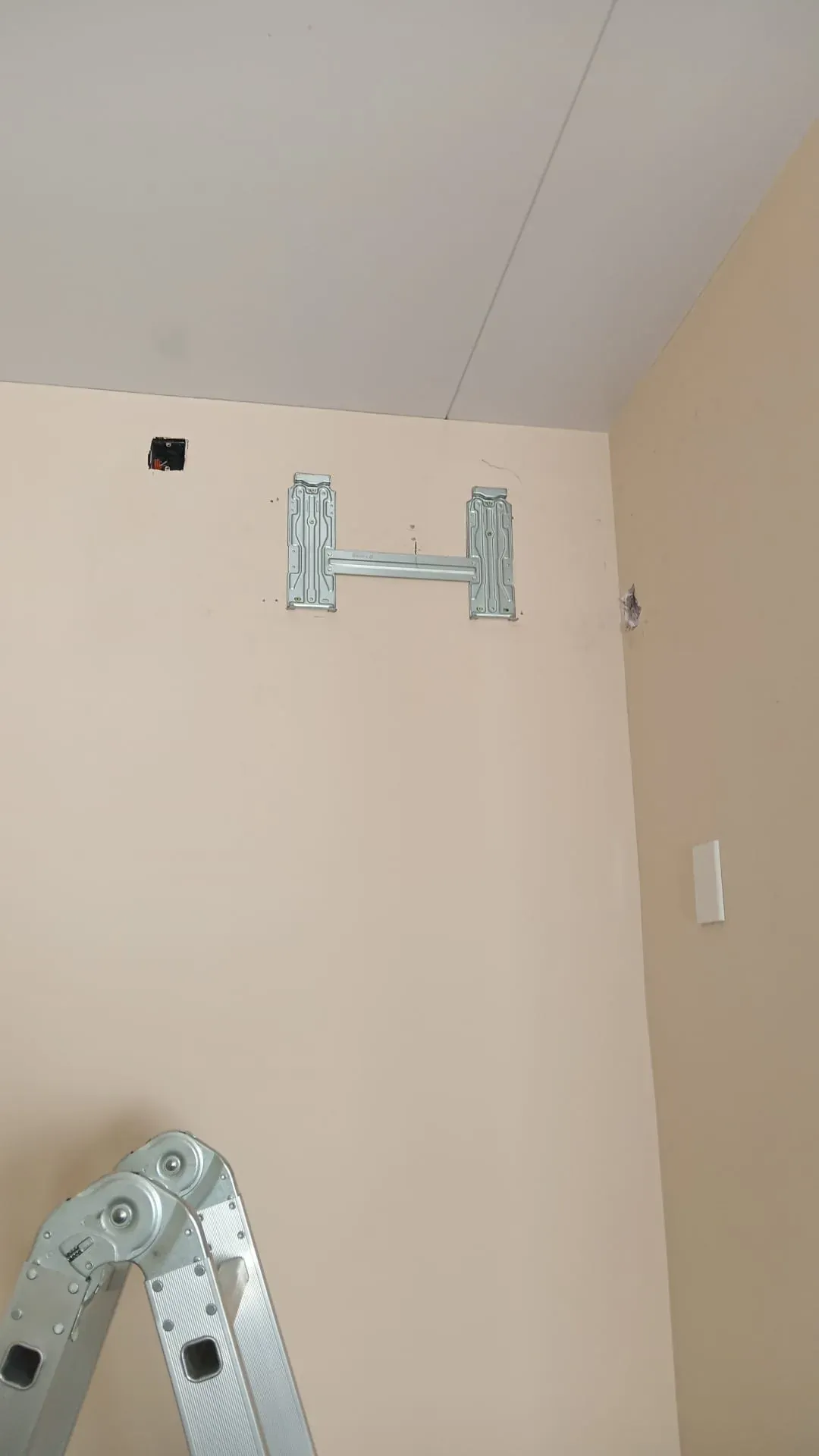Soporte metálico de la unidad interior de un aire acondicionado split colocado en la pared, listo para montar el equipo